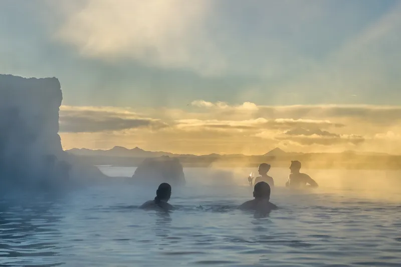 Geothermal swimming pool in Reykjavík with steam rising in winter